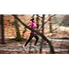 Young woman running outdoors in a city park on a cold fall/winter day (motion blurred image)