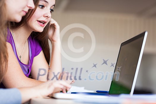 young pretty female college student sitting in a classroom full of students during class young pretty female college student sitting in a classroom full of students during class