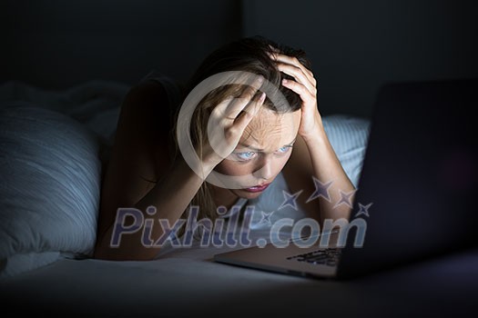 Pretty young woman watching something awful/sad on her laptop in bed Pretty young woman watching something awful/sad on her laptop in bed