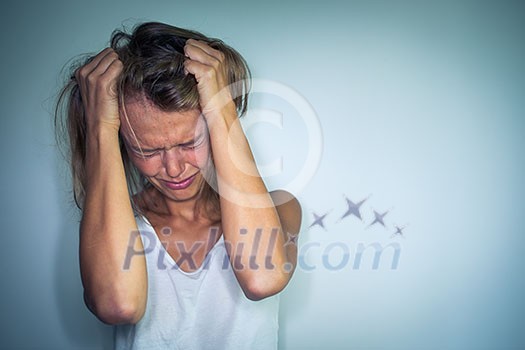 Young woman suffering from a severe depression, anxiety/sudden fear (very harsh lighting is used on this shot to underline/convey the gloomy mood of the scene; color toned image) Young woman suffering from a severe depression, anxiety/sudden fear (very harsh lighting is used on this shot to underline/convey the gloomy mood of the scene; color toned image)