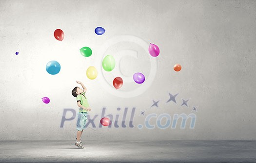 Little cute boy playing joyfully with colorful balloon Little cute boy playing joyfully with colorful balloon