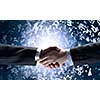 Close up of business handshake on digital background