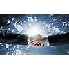 Close up of business handshake on digital background