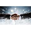 Close up of business handshake on digital background