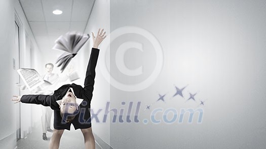 Young businesswoman trying to evade from thrown book Young businesswoman trying to evade from thrown book