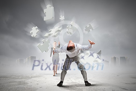 Businessman bent over and evading from flying puzzle element Businessman bent over and evading from flying puzzle element