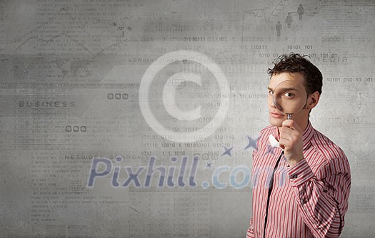 Funny image of young man looking in magnifying glass Funny image of young man looking in magnifying glass