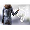 Rear view of businesswoman touching light bulb