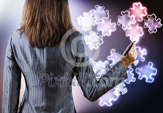 Rear view of businesswoman drawing puzzle elements Rear view of businesswoman drawing puzzle elements