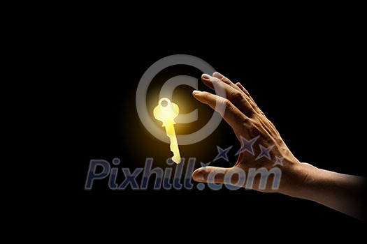 Close up image of business person holding shining key Close up image of business person holding shining key