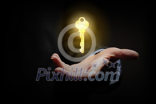 Close up image of business person holding shining key Close up image of business person holding shining key