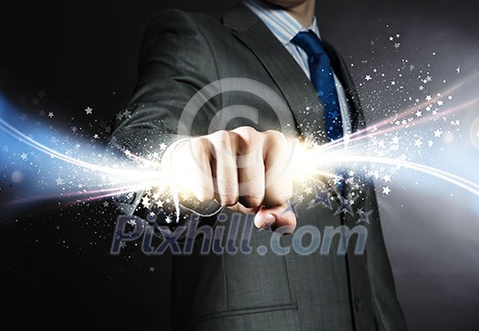 Close up of businessman hand holding light ray in fist Close up of businessman hand holding light ray in fist