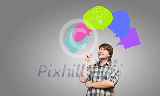 Young thoughtful man and colorful speech bubbles above Young thoughtful man and colorful speech bubbles above