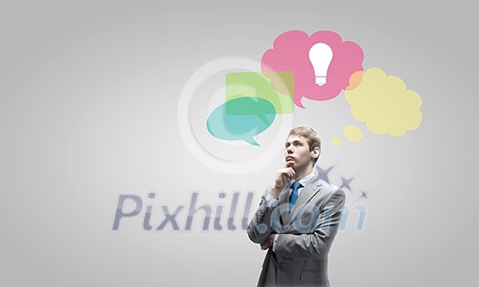 Young thoughtful businessman and colorful speech bubbles above Young thoughtful businessman and colorful speech bubbles above