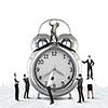 Big old-style clock and many businesspeople around