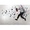 Young businessman running with violin in hand
