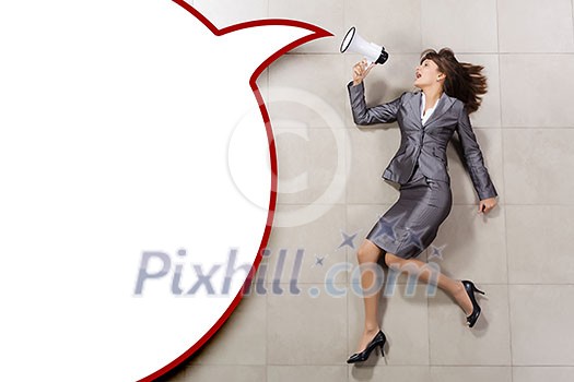 Attractive businesswoman screaming in megaphone. Place for text