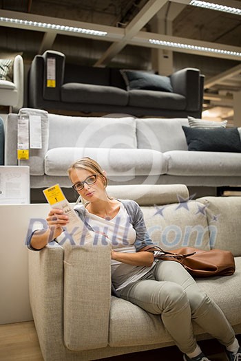 Pretty, young woman choosing the right furniture for her apartment in a modern home furnishings store (color toned image; shallow DOF) Pretty, young woman choosing the right furniture for her apartment in a modern home furnishings store (color toned image; shallow DOF)