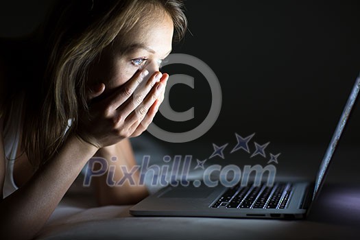 Pretty young woman watching something awful/sad on her laptop in bed Pretty young woman watching something awful/sad on her laptop in bed
