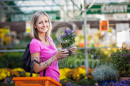 Young woman buying flowers at a garden center Young woman buying flowers at a garden center