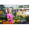 Young woman buying flowers at a garden center