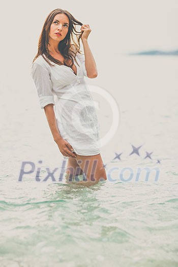 Woman relaxing at the beach with arms open enjoying her freedom, independence, good health, time off. Woman relaxing at the beach with arms open enjoying her freedom, independence, good health, time off.