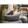 Pretty, young woman choosing the right furniture for her apartment in a modern home furnishings store (color toned image; shallow DOF)