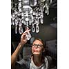 Pretty, young woman choosing the right chandelier for her appartment in a modern home furnishings store (color toned image; shallow DOF)