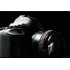 Professional modern DSLR camera low key stock photo/image - Modern DSLR camera with a very wide aperture lens on with highlighted edges against black background