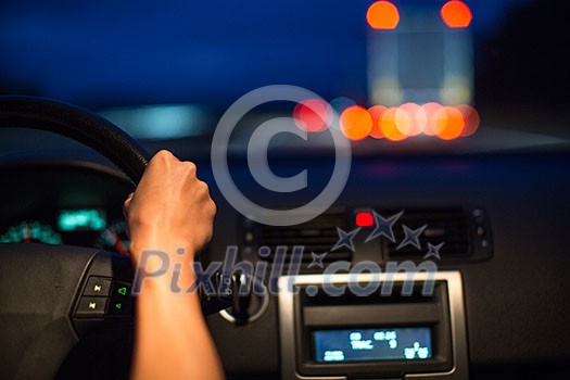 Female drive driving a car at night (shallow DOF; colour toned image) Female drive driving a car at night (shallow DOF; colour toned image)