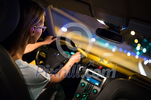 Female drive driving a car at night (shallow DOF; colour toned image) Female drive driving a car at night (shallow DOF; colour toned image)