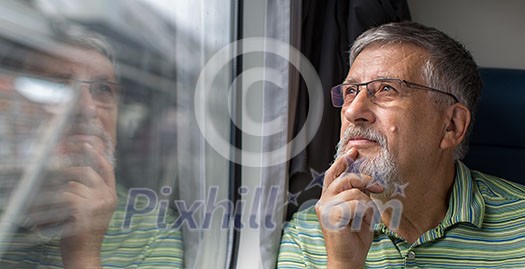 Senior man enjoying a train travel - leaving his car at home, he savours the time spent travelling, looks out of the window, has time to admire the landscape passing by Senior man enjoying a train travel - leaving his car at home, he savours the time spent travelling, looks out of the window, has time to admire the landscape passing by