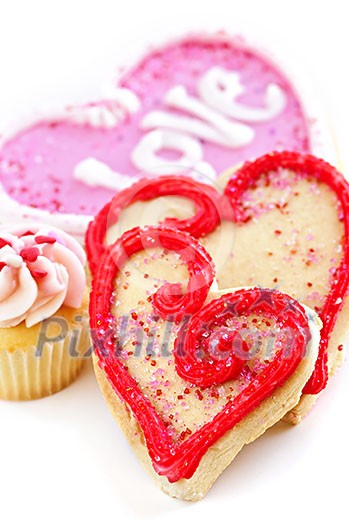 Homemade baked shortbread Valentine cookies and cupcake with icing on white background Homemade baked shortbread Valentine cookies and cupcake with icing on white background