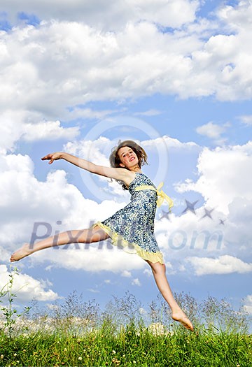 Young teenage girl jumping in summer meadow amid wildflowers Young teenage girl jumping in summer meadow amid wildflowers