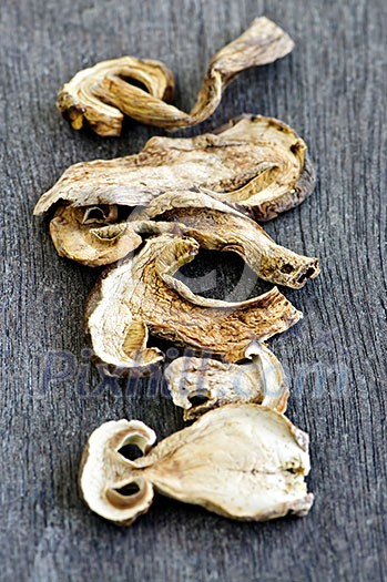 Dried sliced porcini mushrooms against wood background Dried sliced porcini mushrooms against wood background