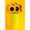 Bouquet of sunflowers in yellow metal vase