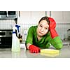 Tired girl doing kitchen cleaning chores with rubber gloves