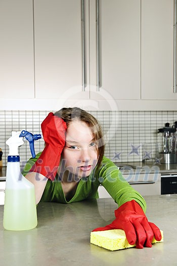 Tired girl doing kitchen cleaning chores with rubber gloves Tired girl doing kitchen cleaning chores with rubber gloves