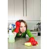 Tired girl doing kitchen cleaning chores with rubber gloves