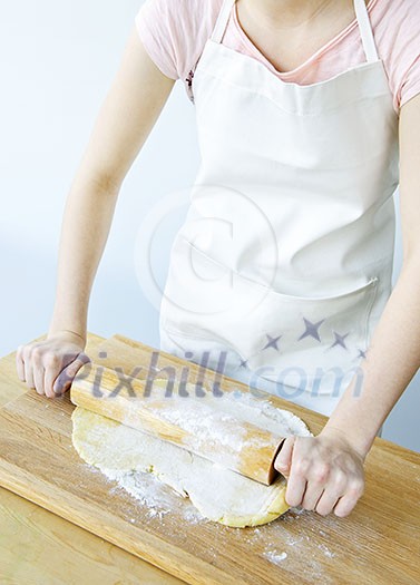Spreading out cookie dough with wooden rolling pin