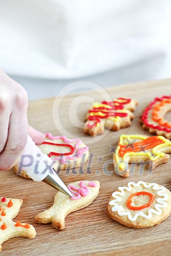 Decorating homemade shortbread cookies with icing from piping bag Decorating homemade shortbread cookies with icing from piping bag