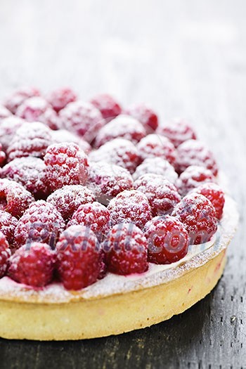 Fresh dessert fruit tart covered in raspberries Fresh dessert fruit tart covered in raspberries