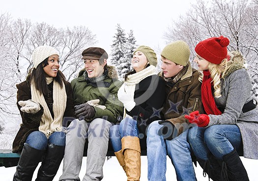 Group of young friends talking and laughing outdoors in winter Group of young friends talking and laughing outdoors in winter