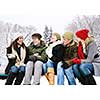 Group of young friends talking and laughing outdoors in winter