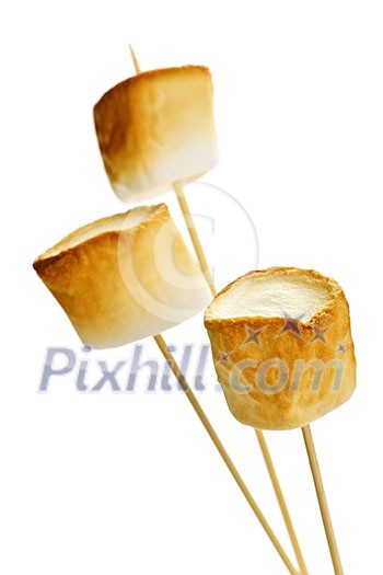 Three golden toasted marshmallows on wooden skewers Three golden toasted marshmallows on wooden skewers
