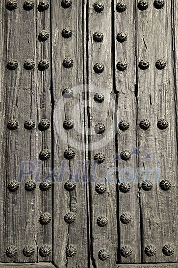 Background of old wooden door with metal studs Background of old wooden door with metal studs