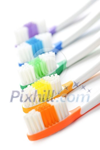 Close up of multicolored toothbrushes on white background Close up of multicolored toothbrushes on white background