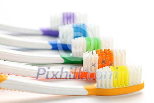 Close up of multicolored toothbrushes on white background Close up of multicolored toothbrushes on white background