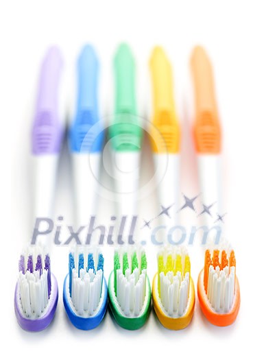 Close up of multicolored toothbrushes on white background Close up of multicolored toothbrushes on white background