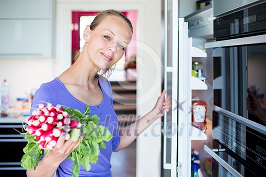 Pretty, young woman taking fresh vegetables from her fridge - being on a gluten free vegan diet does not seem to be a problem for her (shallow DOF; color toned image) Pretty, young woman taking fresh vegetables from her fridge - being on a gluten free vegan diet does not seem to be a problem for her (shallow DOF; color toned image)